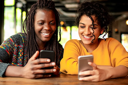 Two Women Looking At Their Phones