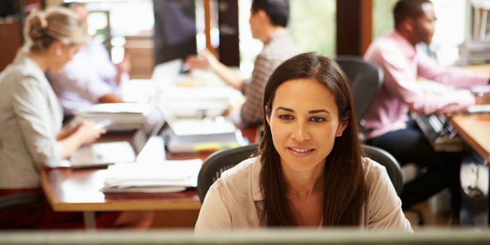 bigstock-Businesswoman-Working-At-Desk-624826161